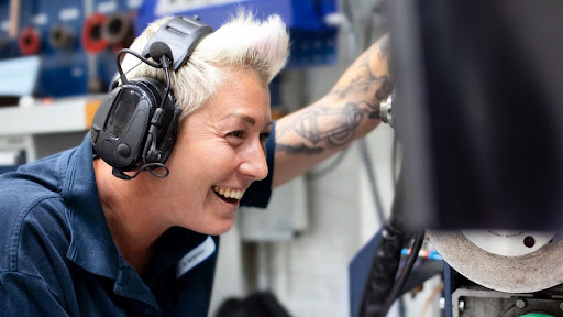 A Tetra Pak service engineer laughing while working on production line equipment
