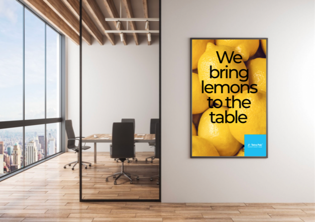 Out-of-home poster reading 'We bring lemons to the table' in an office environment